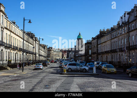 Straßenszene in Edinburgh mit in der Mitte der Straße geparkten Autos Stockfoto