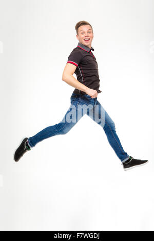 Voller Länge Foto von aufgeregt, glücklichen jungen Mann im schwarzen T-shirt und Jeans, springen und laufen isolierten auf weißen Hintergrund Stockfoto