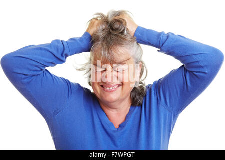 Frustriert pensionierte Frau zieht ihr graues Haar Stockfoto