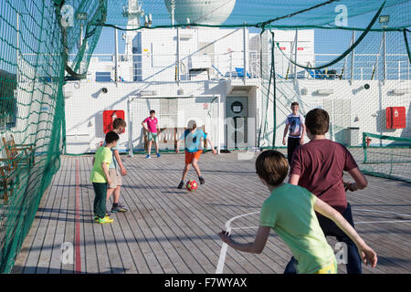 Jungs spielen Fußball an Bord einer Kreuzfahrt Schiff auf See Stockfoto