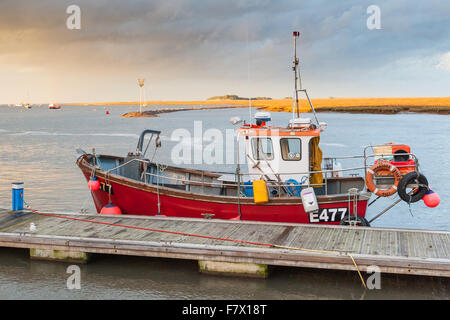 Boote bei Sonnenuntergang am Hafen in Wells nächsten The Sea Norfolk mit einem stürmischen Himmel im Hintergrund. Stockfoto