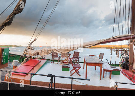 Boote bei Sonnenuntergang am Hafen in Wells nächsten The Sea Norfolk mit einem stürmischen Himmel im Hintergrund. Stockfoto