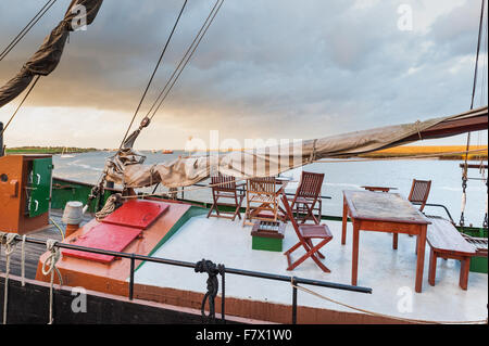 Boote bei Sonnenuntergang am Hafen in Wells nächsten The Sea Norfolk mit einem stürmischen Himmel im Hintergrund. Stockfoto