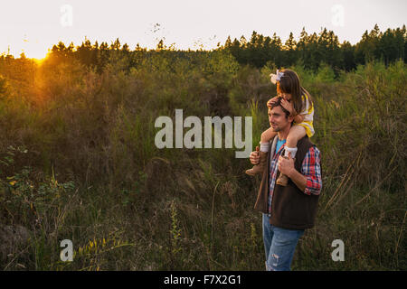 Vater mit Tochter auf den Schultern auf dem Lande