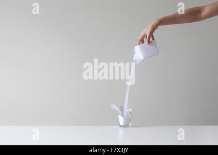 Frau, die konzeptionelle Milch in ein Glas gießen Stockfoto