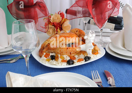 Gegrilltes Hähnchen mit Reis und getrockneten Früchten auf dem Esstisch Stockfoto