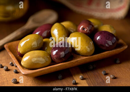 Eine Schüssel mit leckeren gemischten Oliven auf einem rustikalen Tisch. Stockfoto