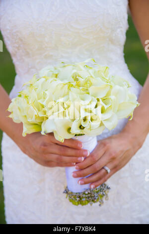 Braut hält ihren Blumenstrauß mit Schmuck von ihr Großmutter umwickelt. Stockfoto