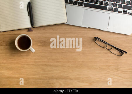 Notizblock mit Stift und Laptop auf Holztisch. Bild mit Platz für Ihren Text. Stockfoto