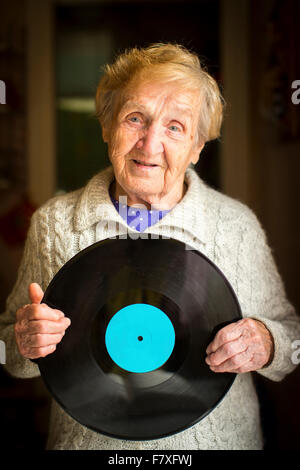 Ältere Frau mit Lp Schallplatte in seinen Händen. Setzen Sie auf Vinyl für Ihren Text. Stockfoto