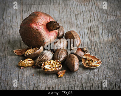 Granatapfel und Pecan-Nüssen auf einem Holztisch Stockfoto