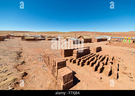 Bauerndorf in der desertic Landschaft im Hochland Anden in Bolivien. Lehmziegel, bekannt als "Adobe", im Vordergrund. CL Stockfoto