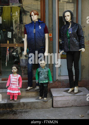 Mannequin Modelle anzeigen vor einem Schaufenster  Zwei Erwachsene und zwei Kinder tragen Artikel zum Verkauf stehen. Stockfoto