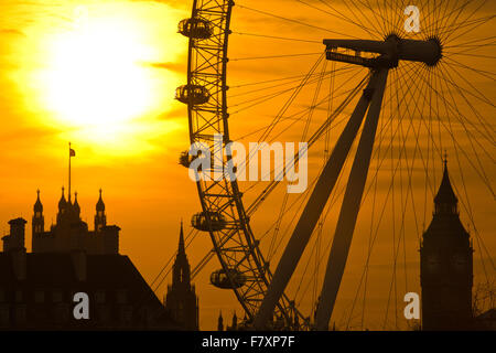 Westminster, London, England, Vereinigtes Königreich 3. Dezember 2015. Die Winter Sonne untergeht durch Gießen einen gelben Dunst über den Wolken auf einem Dezemberabend gesehen, obwohl die London Eye über die Skyline von Westminster, London, UK-Credit: Jeff Gilbert/Alamy Live News Stockfoto