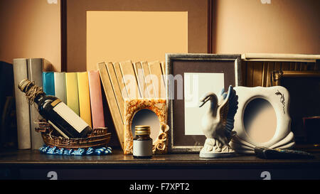 Altes Regal mit Büchern, Souvenirs und leere Bilderrahmen. Stockfoto