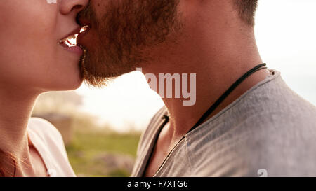 Schuss von zärtlich junge Paar küssen im freien hautnah. Der junge Mann und Frau in der Liebe beschnitten. Stockfoto