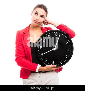 Gelangweilte Geschäftsfrau hält eine große Uhr an den Händen Stockfoto