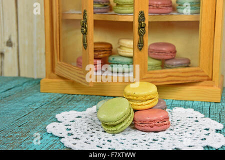 Französische Macarons auf weißer Spitze Deckchen mit Makronen im Schrank. Stockfoto