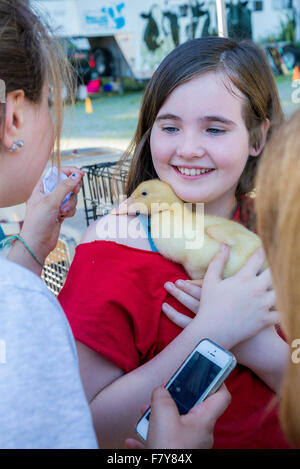 Junges Mädchen hält Baby Entchen auf Frühjahrsmesse, Stockfoto