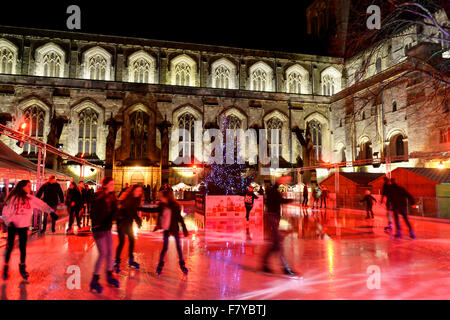 Skater auf der Eisbahn auf dem Gelände der Winchester Cathedral, Winchester, Hampshire, UK, wo die jährlichen Weihnachten markieren Stockfoto