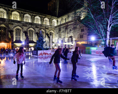 Skater auf der Eisbahn auf dem Gelände der Winchester Cathedral, Winchester, Hampshire, UK, wo die jährlichen Weihnachten markieren Stockfoto