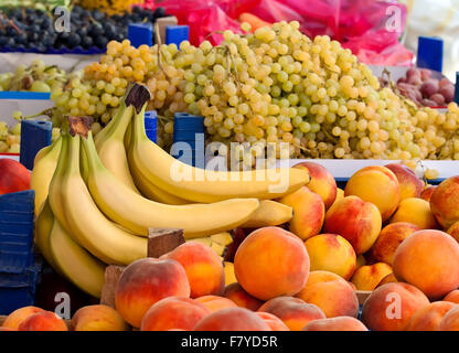 Haufen von frischen Bio-Pfirsiche, Trauben und Bananen zu einem türkischen Straßenmarkt Stockfoto