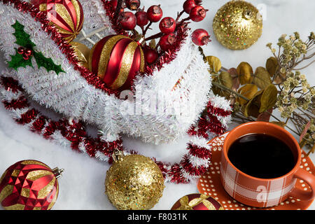 Wohnkultur Santa und seinem Schlitten auf Schnee Baum Dekorationen Tisch setzen und begleitet von einer warmen Tasse Kaffee Stockfoto