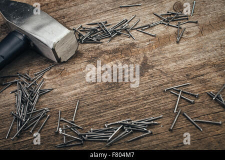 Chrom, Hammer und Nägeln auf Holzbrett Stockfoto