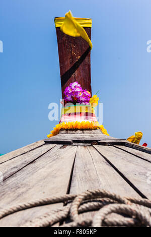 Der Bogen von einer traditionellen thailändischen Longtail-Boot verziert mit Bändern und gelbe Blumen als ein Talisman Stockfoto