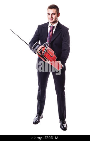ein junger Geschäftsmann hält eine rote Motorsäge isoliert auf einem weißen Hintergrund Stockfoto
