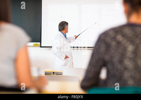 Senior Chemieprofessor geben einen Vortrag vor Klassenzimmer voller Studenten (flachen DOF; getönten Farbbild) Stockfoto