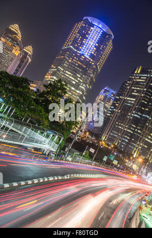 Verkehr in der Nacht in Jakarta, Indonesien Hauptstadt Hauptstraße gesäumt von Banken, Hotels und Luxus Shopping-Malls (Jalan Stockfoto