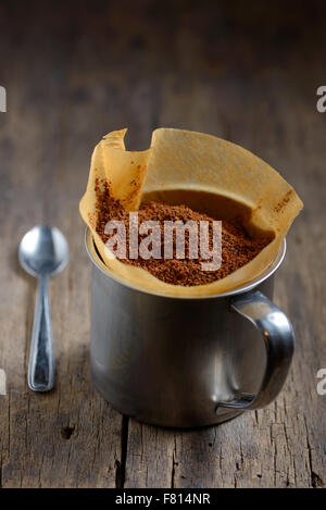 Kaffee in einem Papierhalter und Cup am alten Holztisch Stockfoto