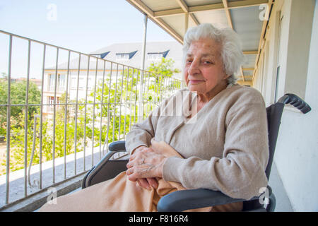 Alte Frau sitzt im Rollstuhl in einem Pflegeheim. Stockfoto