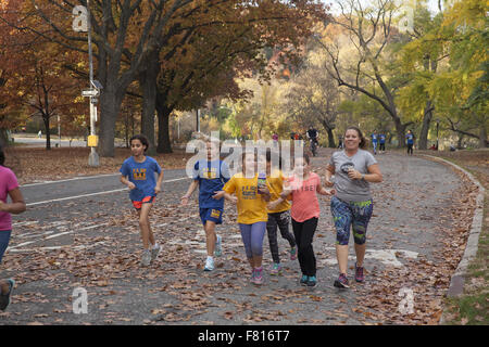 Grundschulkinder zusammen Joggen auf der Straße im Prospect Park in Brooklyn, New York. Stockfoto