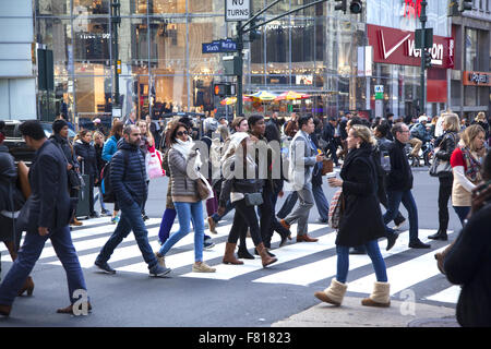 Während der Weihnachtszeit in Manhattan, NYC, laufen die Menschen entlang der 34th Street an der 6th Avenue. Stockfoto