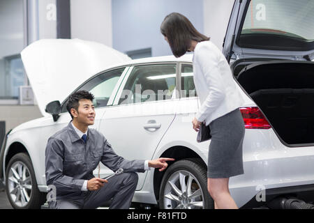 Kfz-Mechaniker im Gespräch mit Kfz-Halter Stockfoto