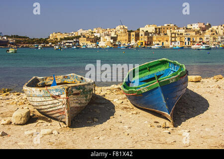 Marsaxlokk in Malta mit 2 unbenutzte Holzboote sitzen neben Wasser Stockfoto