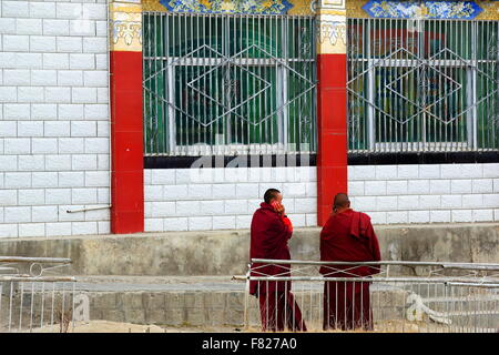 SAKYA, TIBET, CHINA-Oktober 25: Buddhistische tibetische Mönche sprechen auf Handy im freien S.Seat des Sakya-grau Boden Monast.-Tibet Stockfoto