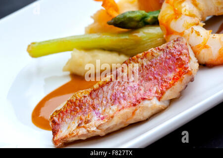 Meerbarben Filet, Spargel, Shrimps, Püree und Sellerie auf einem Teller Stockfoto