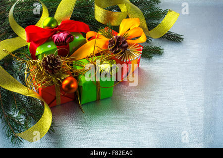 Weihnachts-Dekoration mit Tannenzweigen, Geschenkboxen, Bögen, Kugeln, ornament auf Silber funkelt Hintergrund, selektiven Fokus Stockfoto