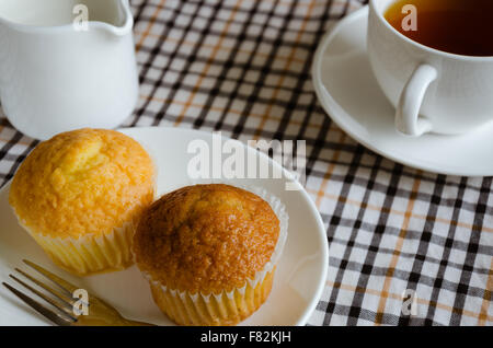 Tasse Kuchen mit Tee und Milch für Teepause. Stockfoto