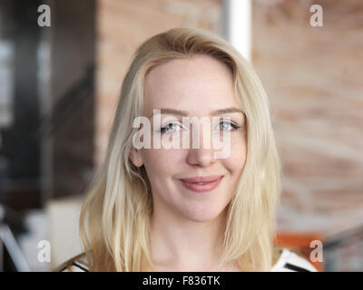 glückliche junge blonde Business Frau Porträt im Büro Stockfoto