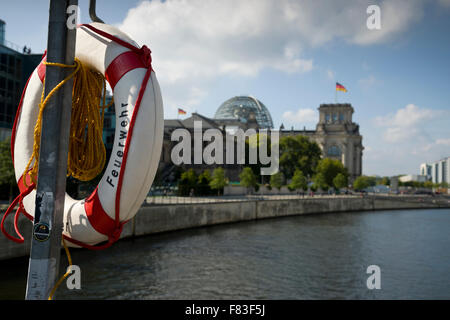 Feuerwehr (Feuerwehr) auf einem Rettungsring oder Rettungsring auf einer Brücke über die Spree mit den Deutschen Reichstag im Hintergrund. Stockfoto