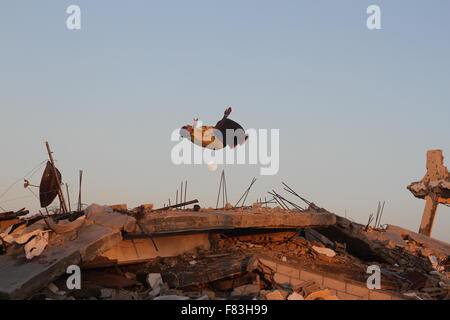 Gaza, Palästina. 5. Dezember 2015. Palästinensische Jugendliche Parkour zu üben auf den Ruinen der Häuser, die während des israelischen Angriffs auf den östlich von Khan Yunis im südlichen Gazastreifen zerstört wurden. Bildnachweis: Ramadan El-Agha/Pacific Press/Alamy Live-Nachrichten Stockfoto