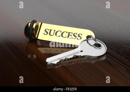 Zimmerschlüssel mit goldenen Schlüsselanhänger Erfolgskonzept auf dem hölzernen Hintergrund Stockfoto