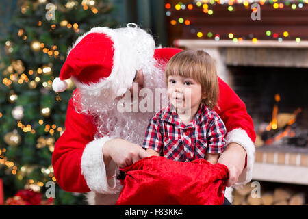 Glückliches Kind junge zieht Geschenk, Santa Claus sack Stockfoto