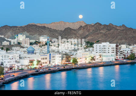 Dawn-Blick auf den Vollmond-Einstellung über den Stadtteil Mutrah und die umliegenden Berge in Muscat, der Hauptstadt des Sultanats Stockfoto