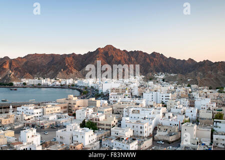 Abenddämmerung Blick auf den Stadtteil Mutrah und die umliegenden Berge in Muscat, der Hauptstadt des Sultanats Oman. Stockfoto