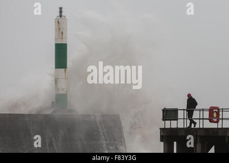 Wales, UK. 5. Dezember 2015 steht der Mensch in der Nähe von den riesigen Wellen, die die konkreten Anlegestelle Misshandlung sind, als Sturm Desmond orkanartigen Winden und rauer See um Aberystwyth an der Westküste von Wales bringt. Bildnachweis: Ian Jones/Alamy Live-Nachrichten Stockfoto